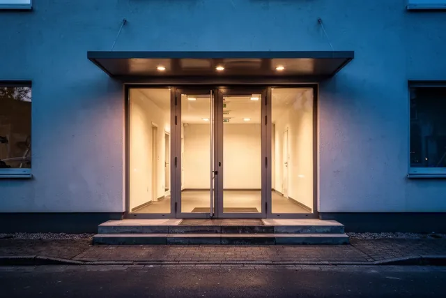 Beleuchteter Eingangsbereich eines Fitnessstudios in der Dämmerung