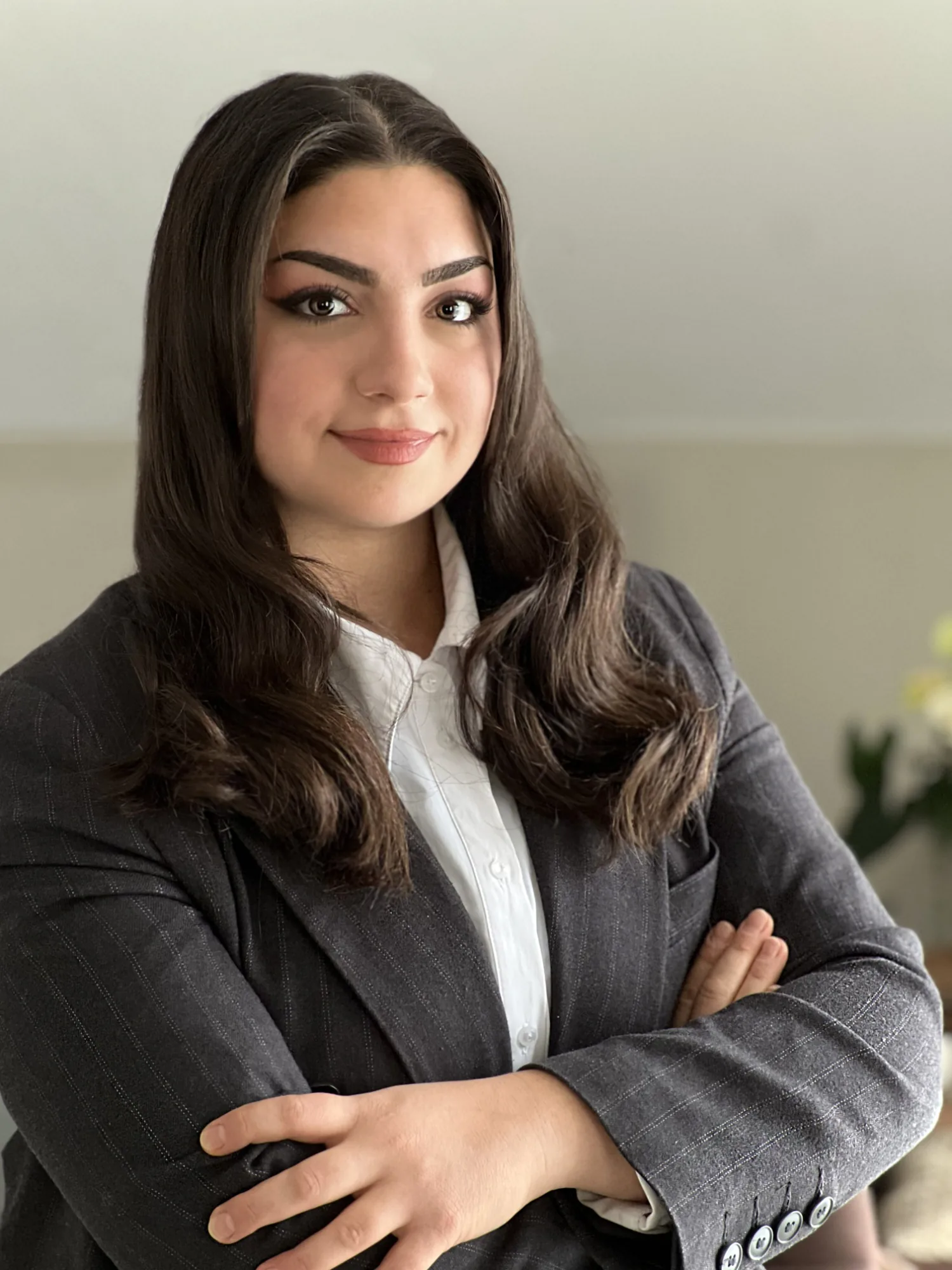 Melike Yildiz, Inhaberin und Architektin M.A., im grauen Blazer vor einem hellen Fenster
