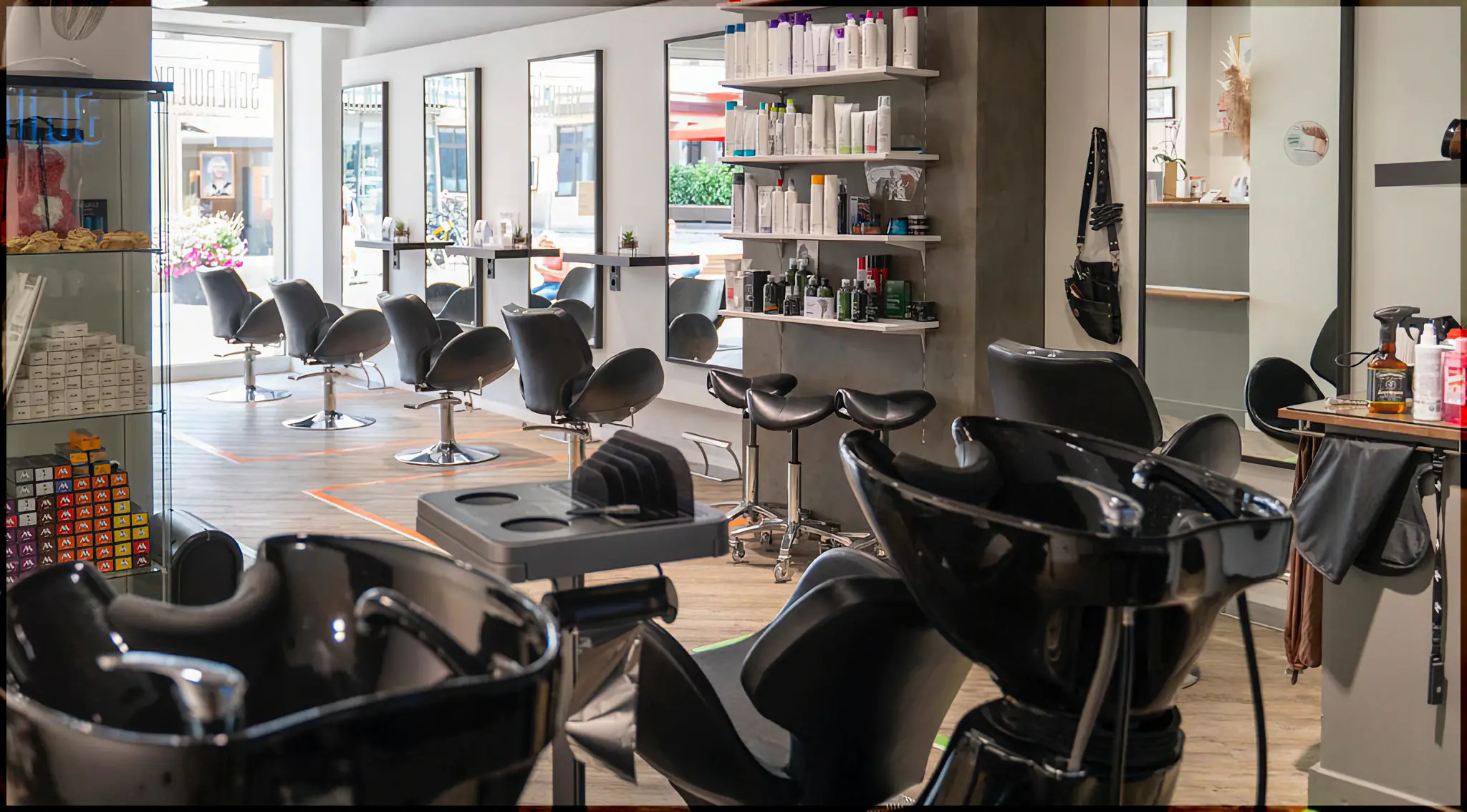 Blick in den Salon Scherwerk: helle Wände, Spiegel und Friseurstühle in einer Reihe